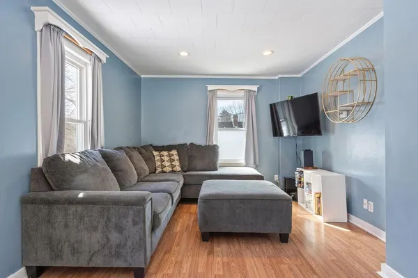 a living room with furniture and a wooden floor