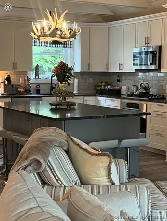 a kitchen with stainless steel appliances granite countertop a stove and a white cabinets