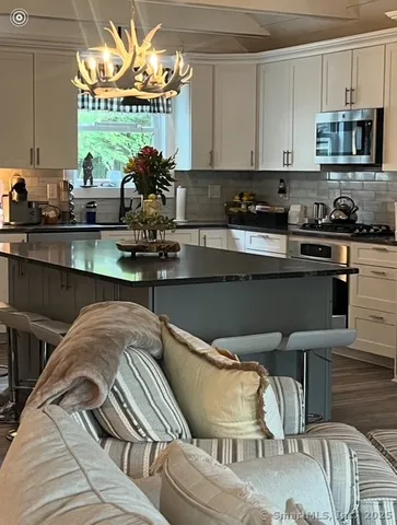 a kitchen with stainless steel appliances granite countertop a stove and a white cabinets