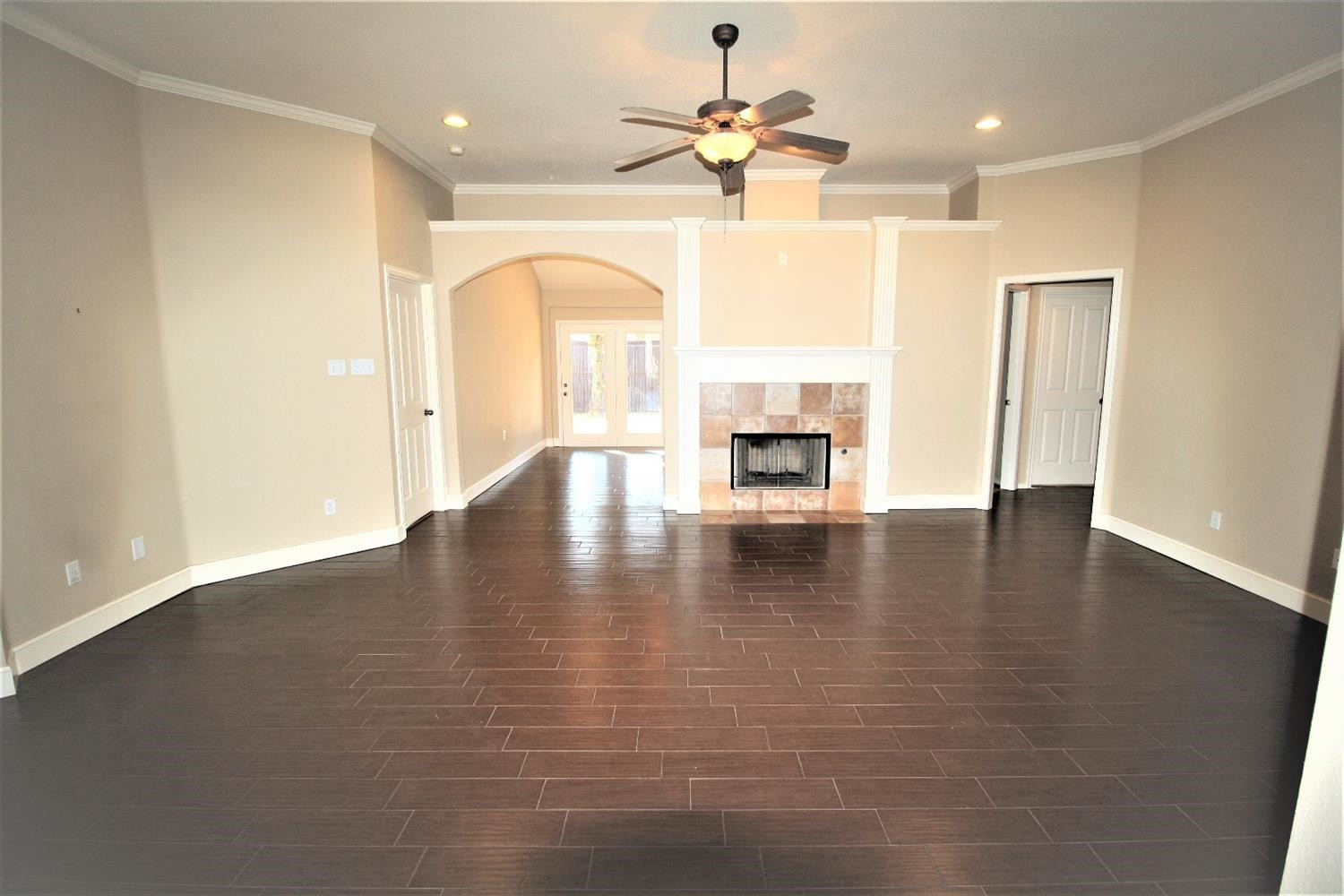 3101 103rd Street Lubbock, TX 79423 - Photo 5 of 10 an empty room with wooden floor fireplace and windows