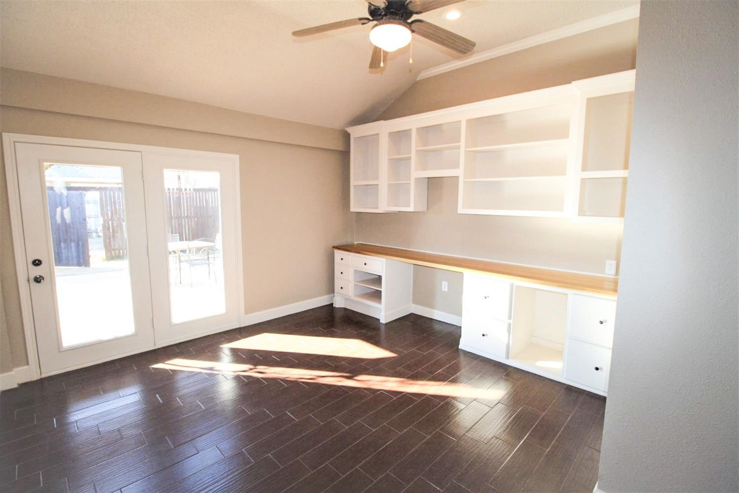 3101 103rd Street Lubbock, TX 79423 - Photo 7 of 10 a view of an empty room with wooden floor and a window