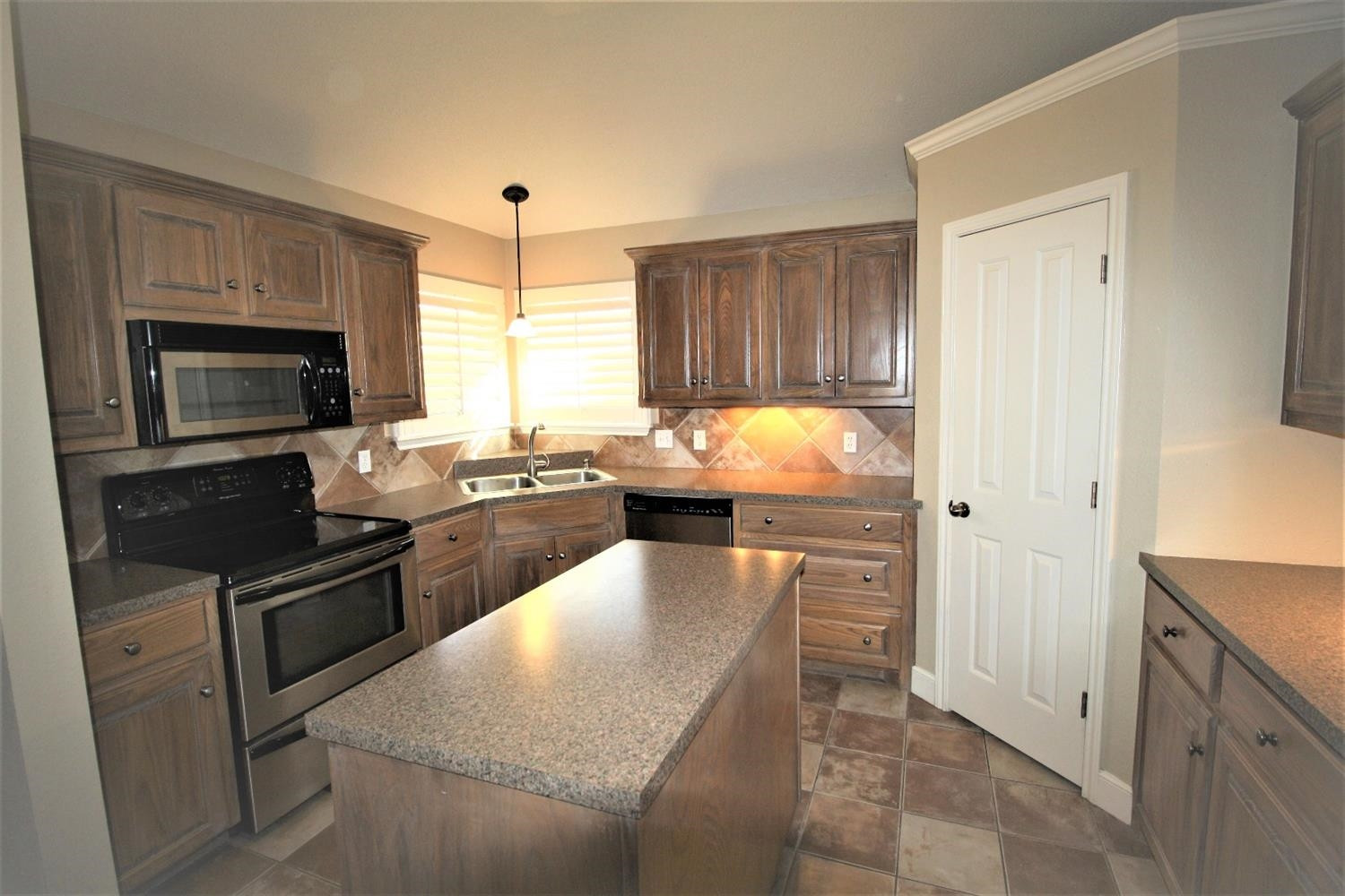 3101 103rd Street Lubbock, TX 79423 - Photo 8 of 10 a kitchen with granite countertop a refrigerator stove and sink
