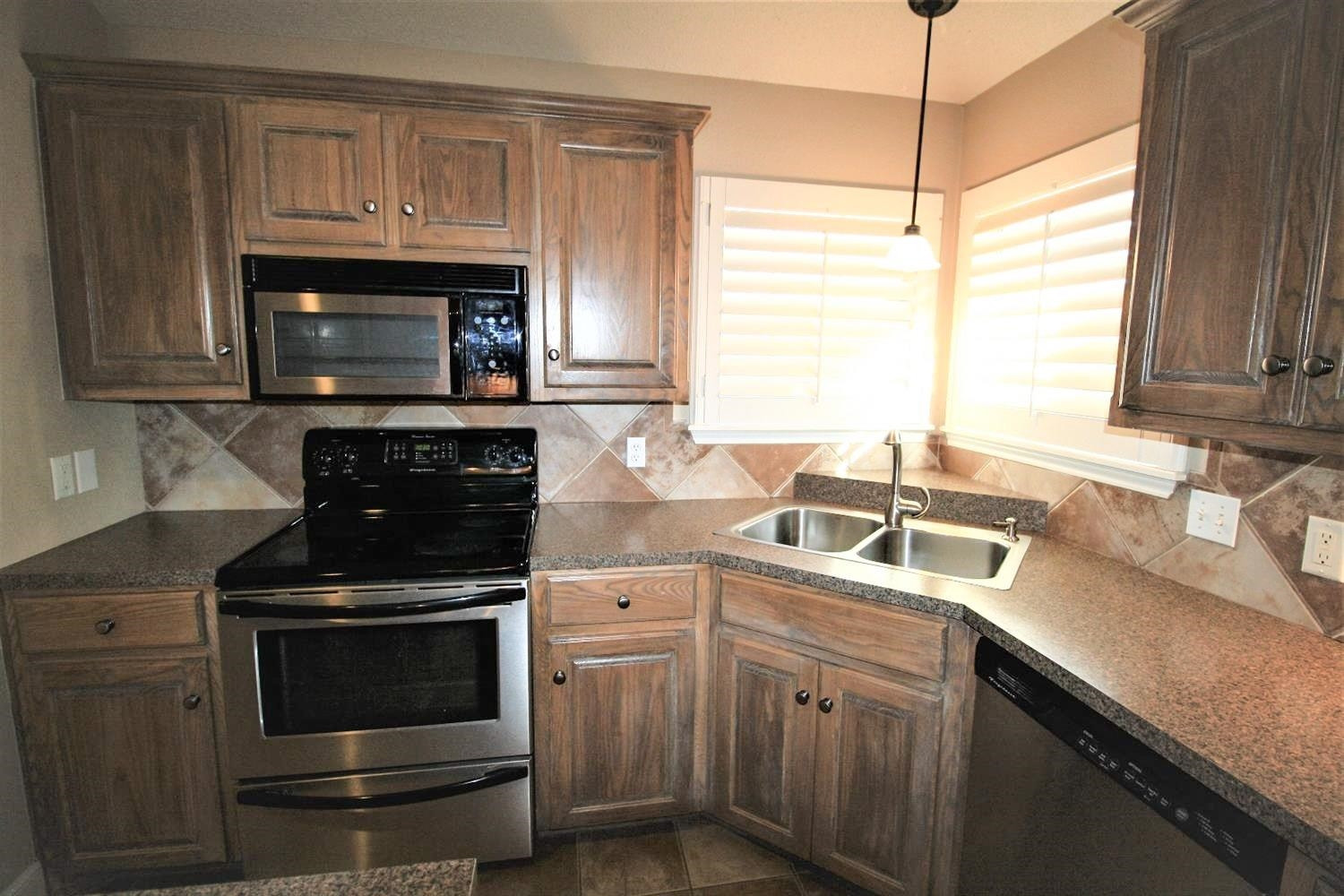 3101 103rd Street Lubbock, TX 79423 - Photo 10 of 10 a kitchen with granite countertop a stove a sink and a microwave