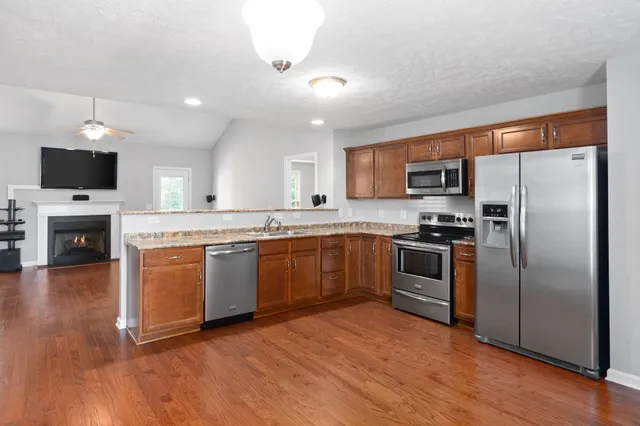 a kitchen with a refrigerator stove and wooden floor