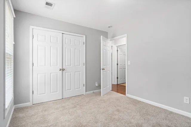 an empty room with windows and closet