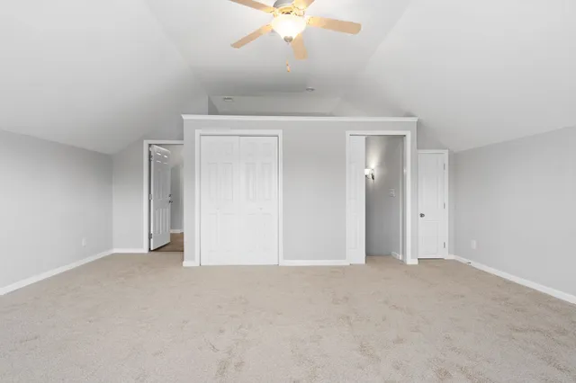 an empty room with a ceiling fan and a window