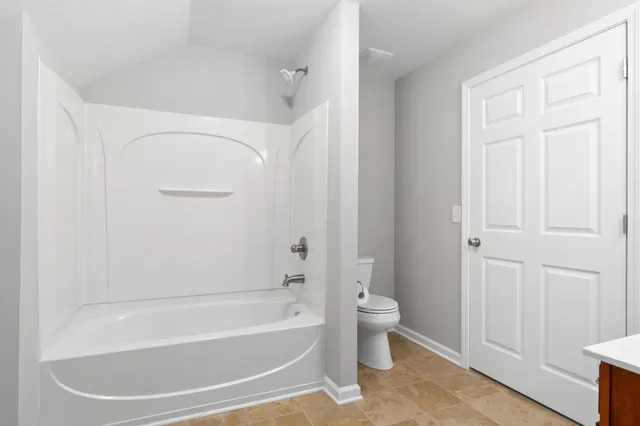 a white bath tub sitting next to a toilet