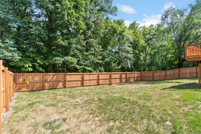 a view of a backyard with a small yard and wooden fence