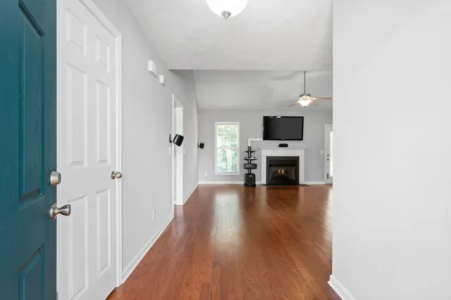 a view of a hallway with wooden floor and a fireplace