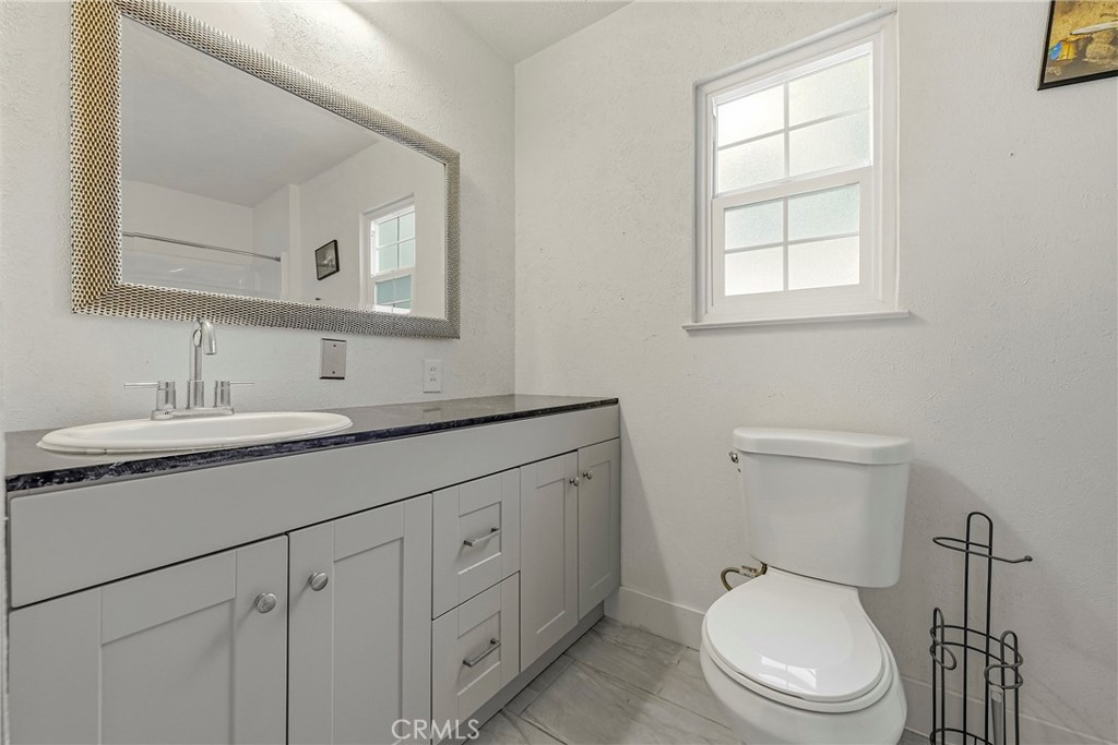 2690 Hawthorne Avenue Merced, CA 95340 - Photo 28 of 36 a bathroom with a toilet sink vanity and mirror