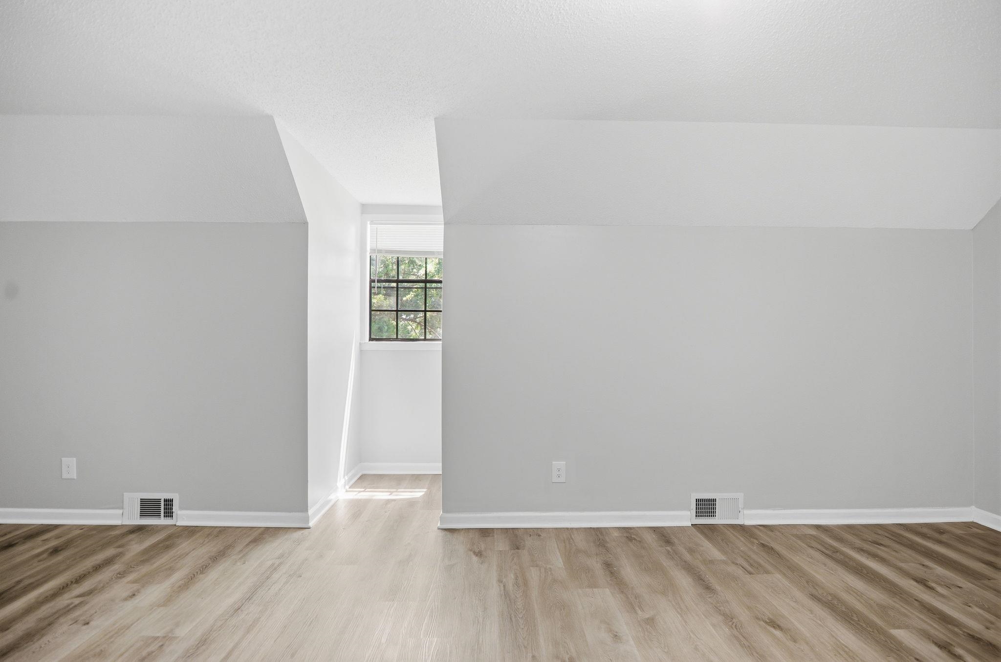 3113 Raleigh Ridge Cove Memphis, TN 38128 - Photo 27 of 38 Room featuring light-toned wood-finish flooring, neutral gray walls, white baseboards, and a window with a paneled grid