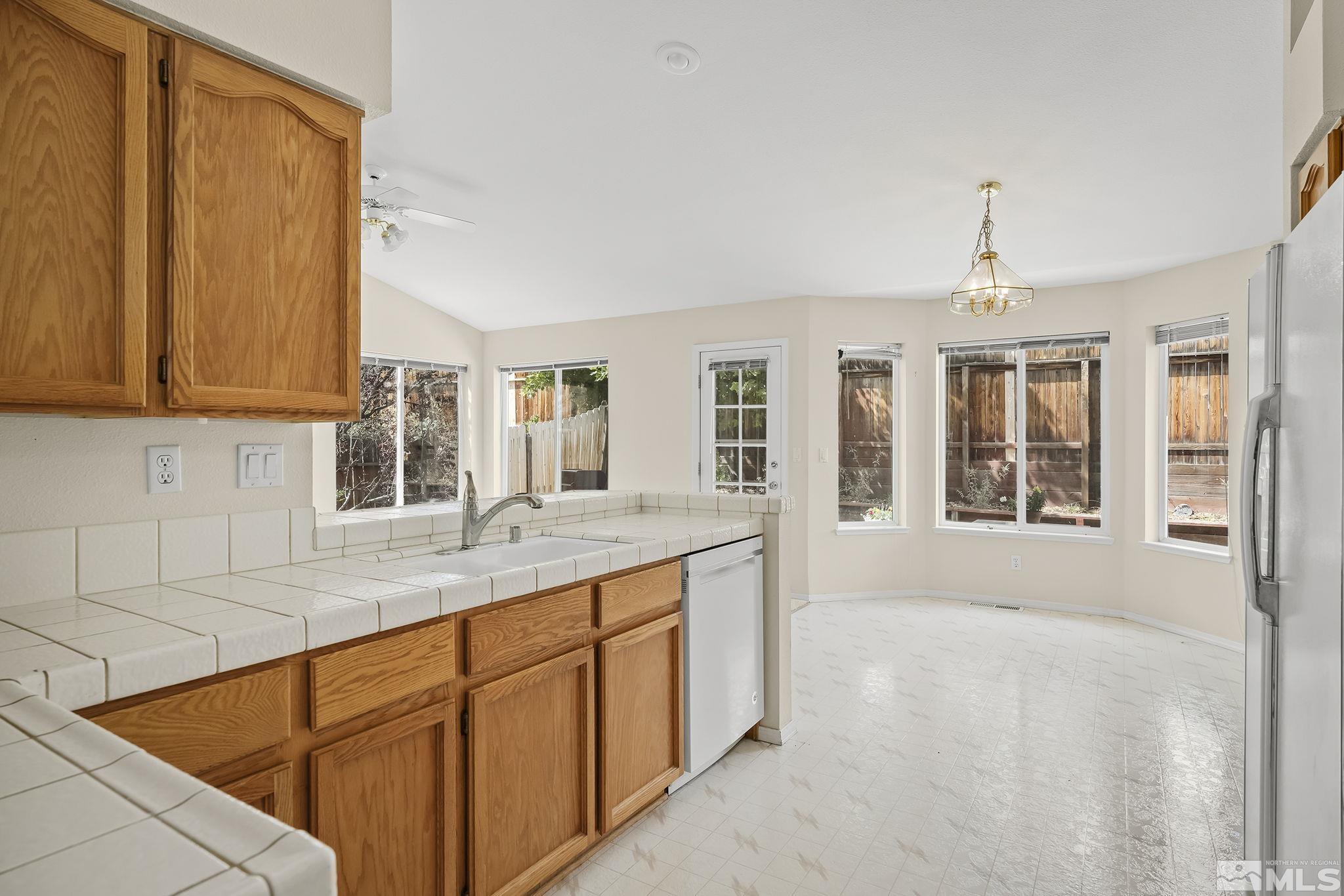 5875 Simons Drive Reno, NV 89523 - Photo 11 of 26 a kitchen with granite countertop a sink cabinets and window
