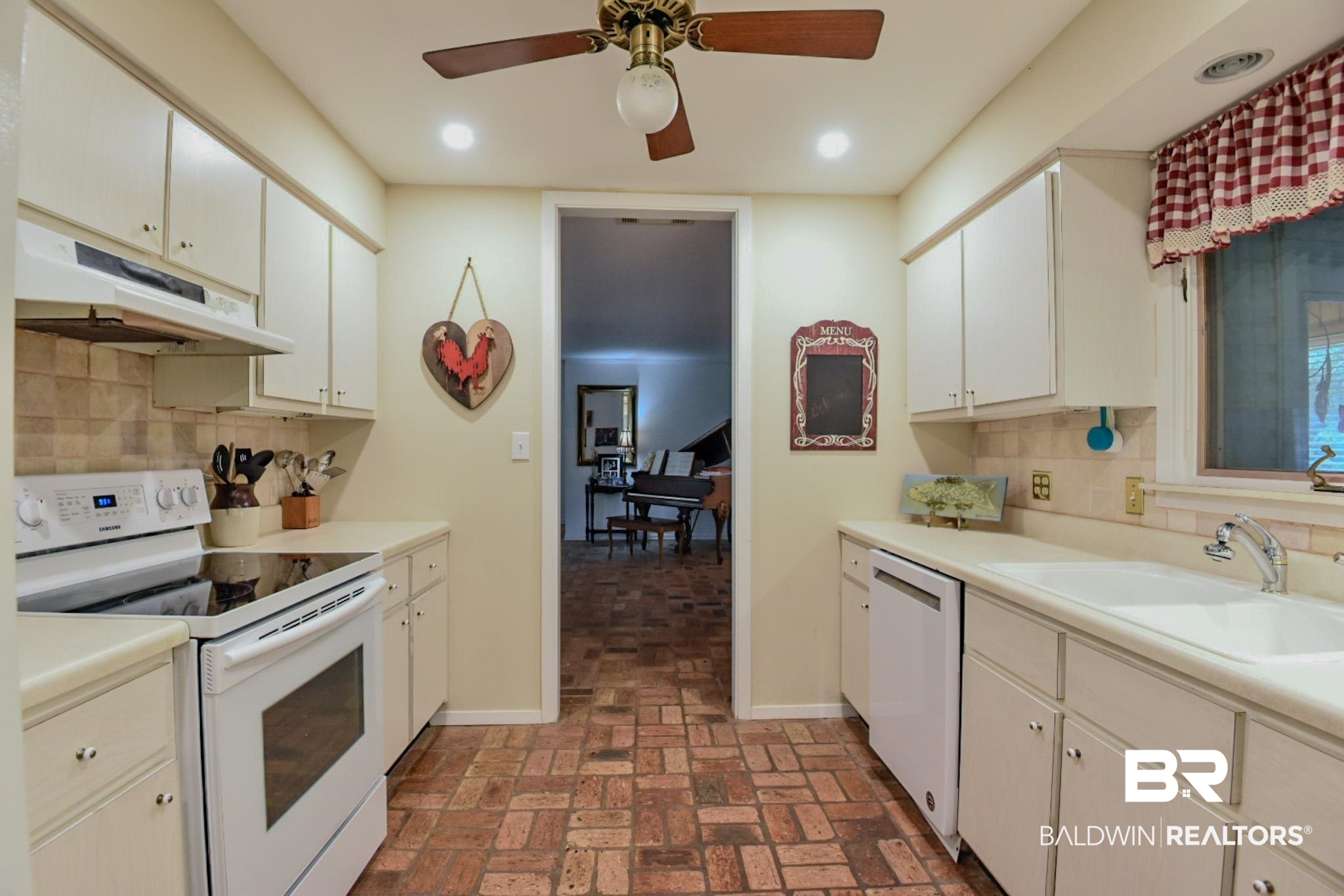 90 Paddock Drive Fairhope, AL 36532 - Photo 9 of 23 Kitchen featuring decorative backsplash, white appliances, under cabinet range hood, brick flooring, and recessed lighting