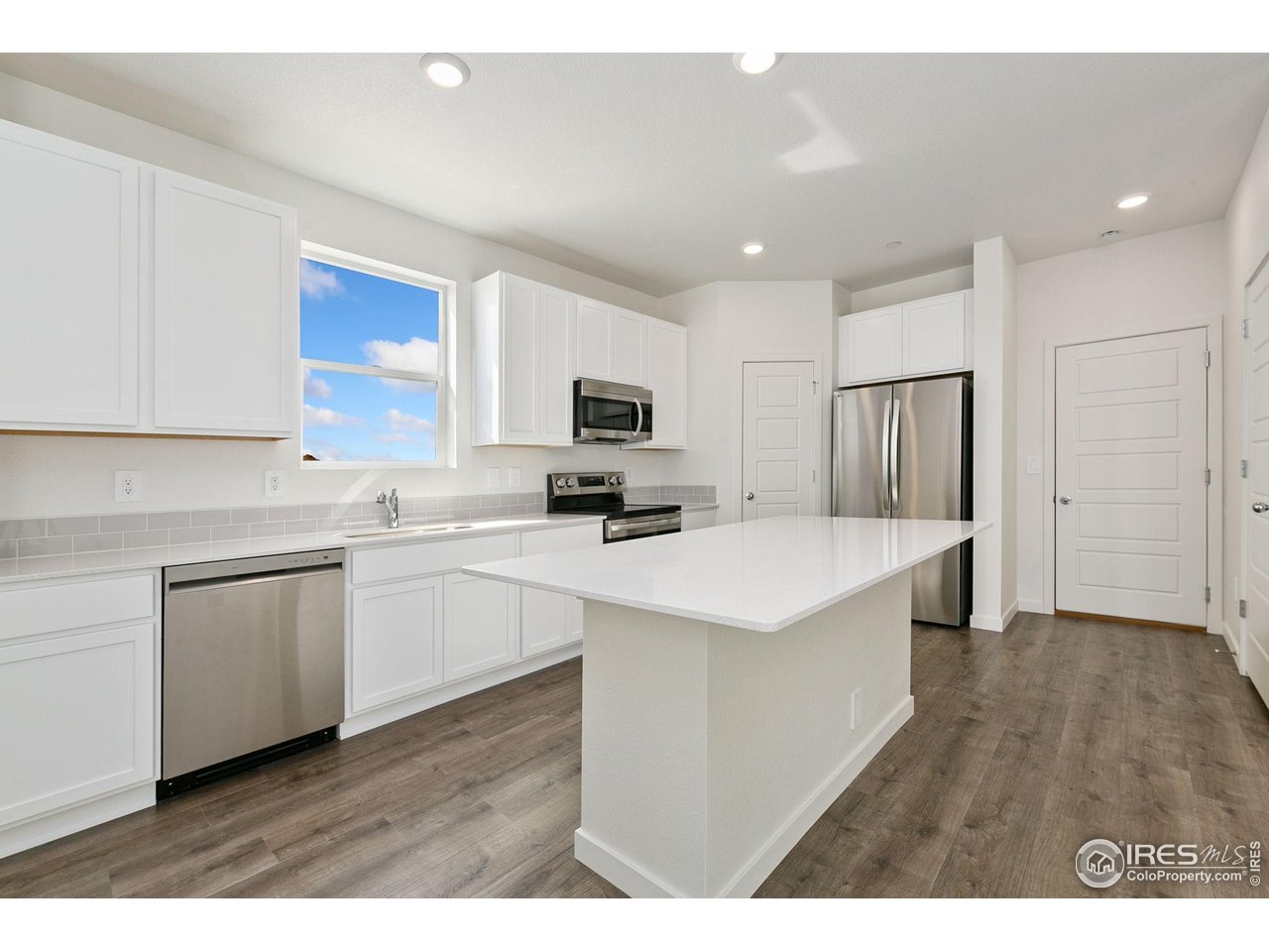 417 Condor Way Johnstown, CO 80534 - Photo 3 of 11 a kitchen with appliances a sink a refrigerator and a microwave