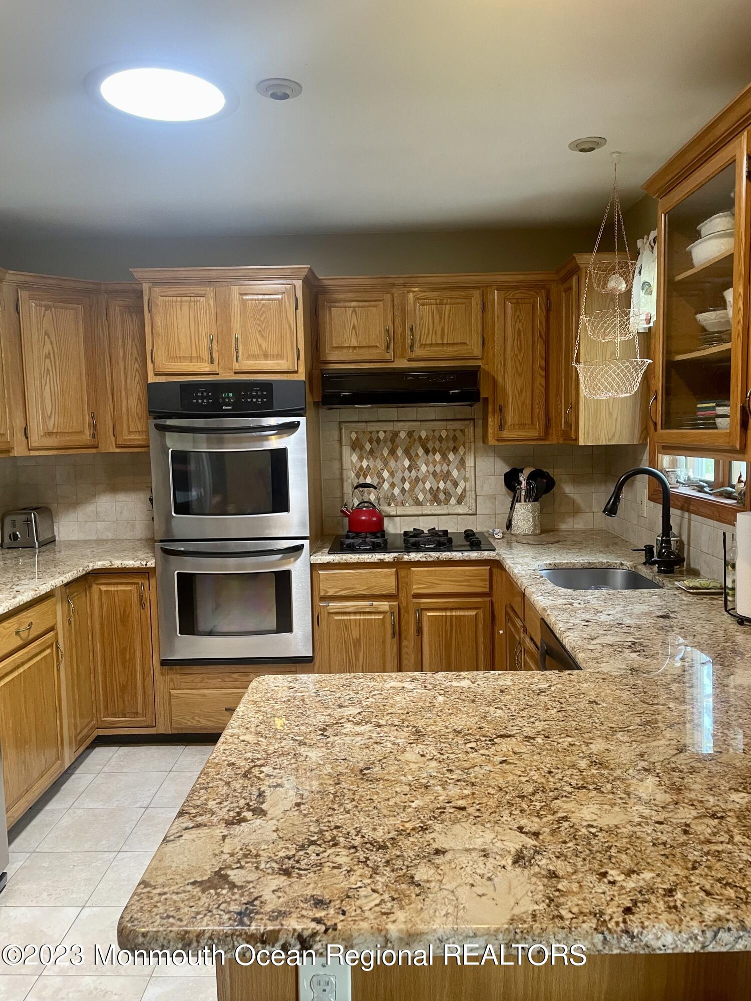 216 Wave Road Manahawkin, NJ 08050 - Photo 8 of 30 a kitchen with stainless steel appliances granite countertop a sink a stove top oven a counter space and cabinets
