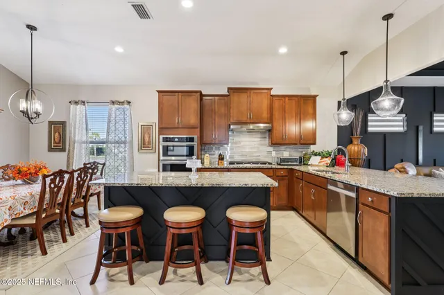 a kitchen with stainless steel appliances granite countertop a sink counter space cabinets and stove
