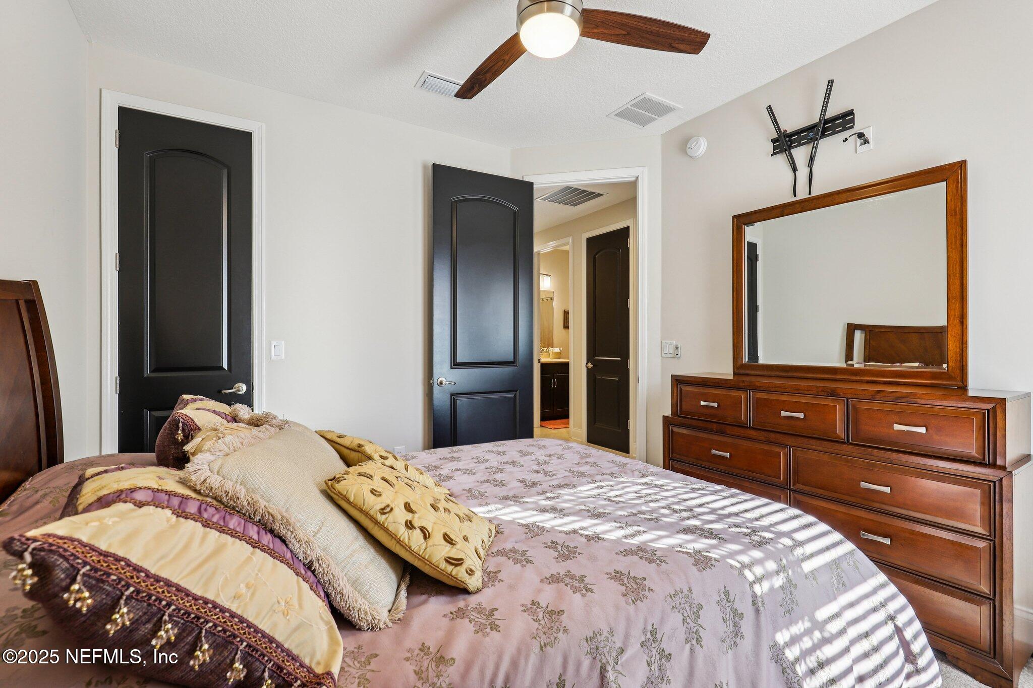 48 Fawn Field Lane St. Augustine, FL 32092 - Photo 29 of 73 a bedroom with a bed and a large mirror on dresser