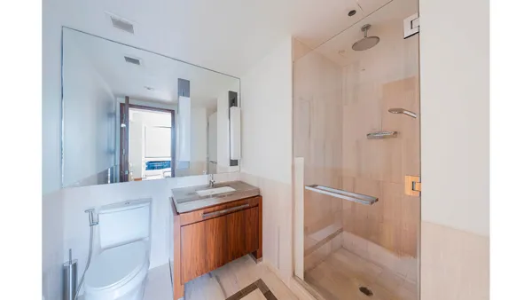 a bathroom with a granite countertop sink toilet and shower