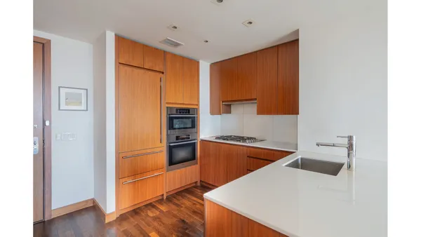 a kitchen with stainless steel appliances granite countertop a refrigerator a stove and a sink with wooden floor