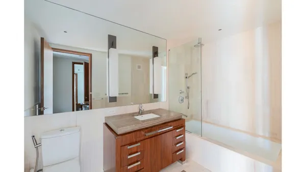 a bathroom with a granite countertop sink a mirror and a bathtub