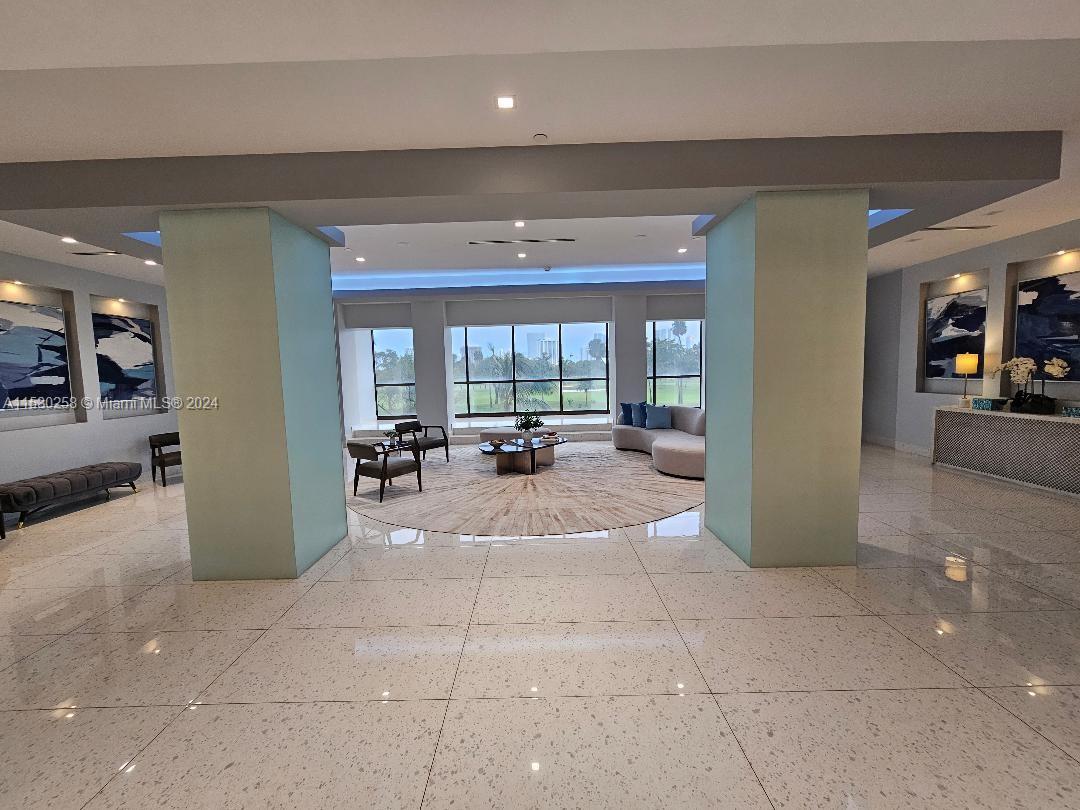 a lobby with furniture and a large mirror