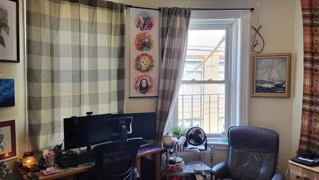 a livingroom with workspace and a window