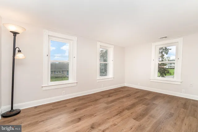 a view of an empty room with wooden floor