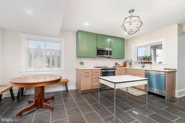 a room with a dining table chairs and view kitchen