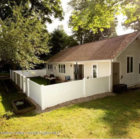 a view of house with yard and trees in the background