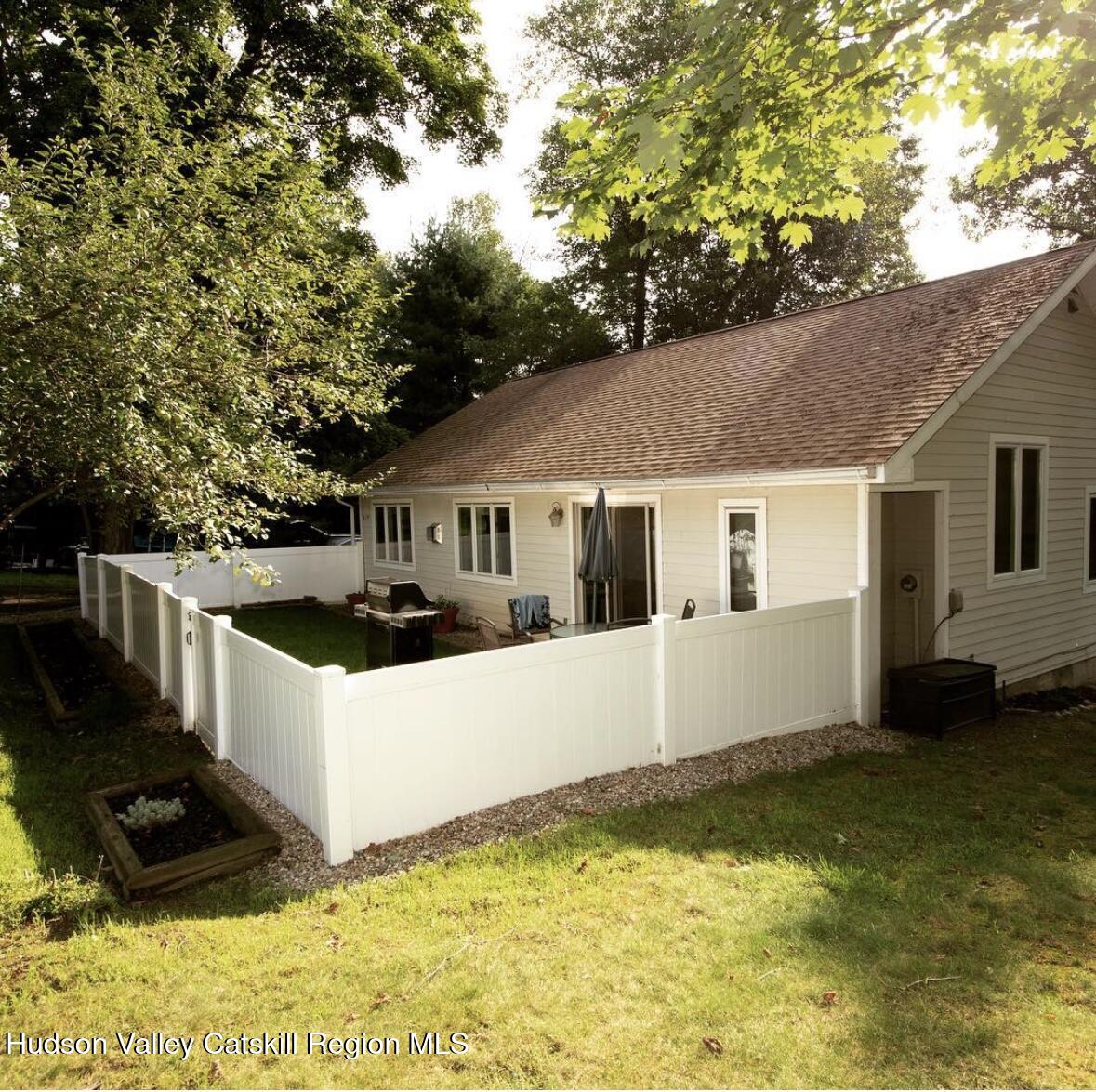 a view of house with yard and trees in the background