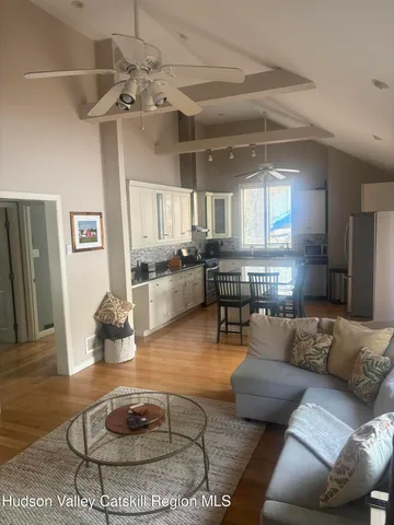 a living room with furniture and kitchen view