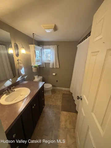 a bathroom with a granite countertop sink a mirror and a shower