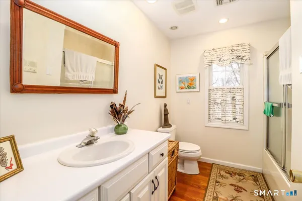 a bathroom with a sink vanity mirror and toilet