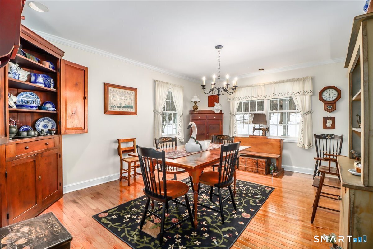 55 Washington Ridge Road New Milford, CT 06776 - Photo 5 of 40 a dining room with wooden floor a chandelier a wooden table and chairs