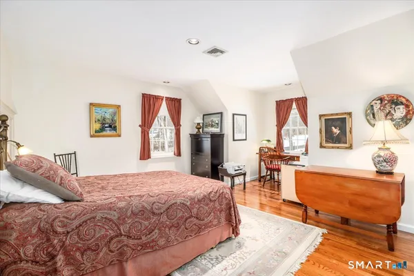 a bedroom with a bed chair and a large window