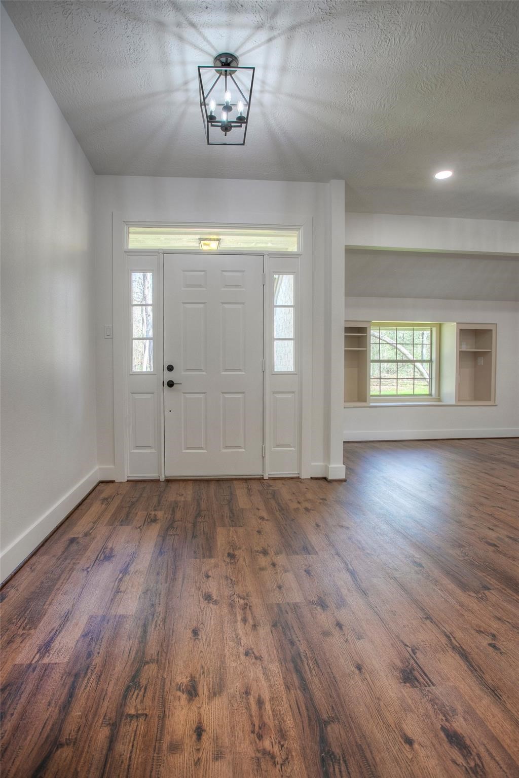 83 Dahlia Road Huntsville, TX 77320 - Photo 5 of 49 an empty room with wooden floor and window