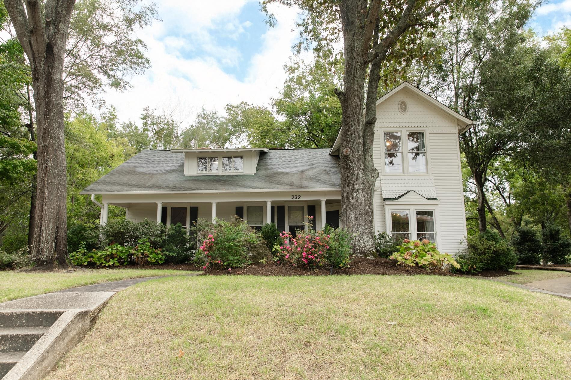 232 West Poplar Avenue Collierville, TN 38017 - Photo 1 of 36 View of front of property featuring a front yard, a porch, roof with shingles, and view of scattered trees