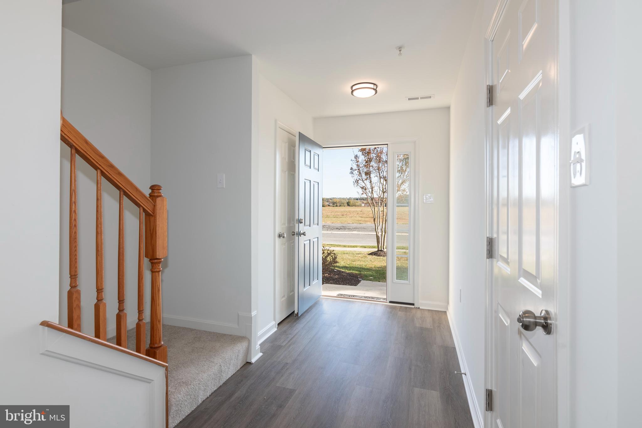 1533 Global Circle Cambridge, MD 21613 - Photo 8 of 27 a view of a hallway with wooden floor and a living room