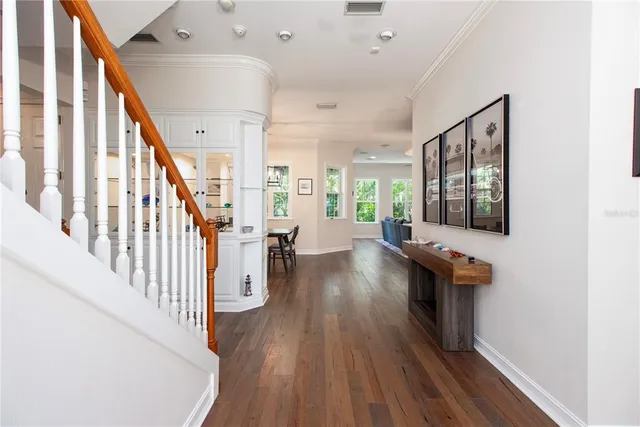 a view of a hallway with wooden floor and staircase