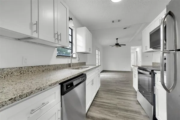 a kitchen with stainless steel appliances granite countertop a sink stove and refrigerator