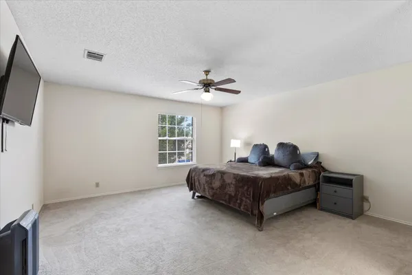 a living room with a bed furniture and a flat screen tv