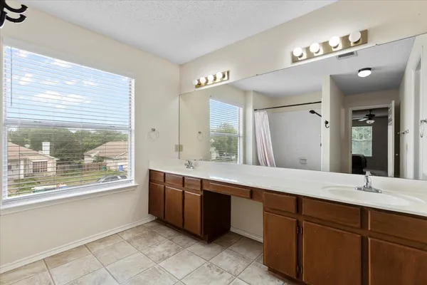 a spacious bathroom with a granite countertop sink mirror and bathtub