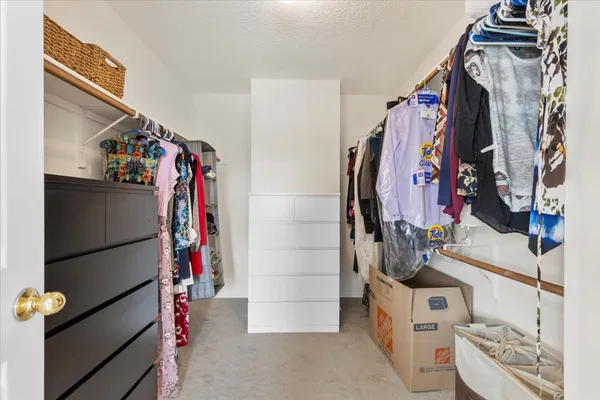 a view of walk in closet with clothes and shoes