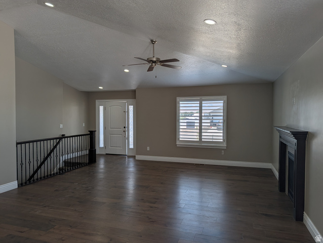 171 South Mustang Road East Grantsville, UT 84029 - Photo 2 of 41 Spacious open-concept room featuring wood-finish flooring, vaulted ceiling with recessed lighting and ceiling fan, and a front entry door with sidelights