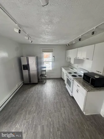 a kitchen with stainless steel appliances a stove top oven a sink and a refrigerator
