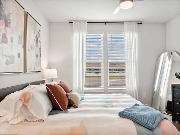 a bedroom with a bed and a large window