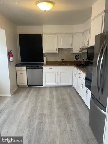 a kitchen with stainless steel appliances a stove a microwave a sink and a refrigerator