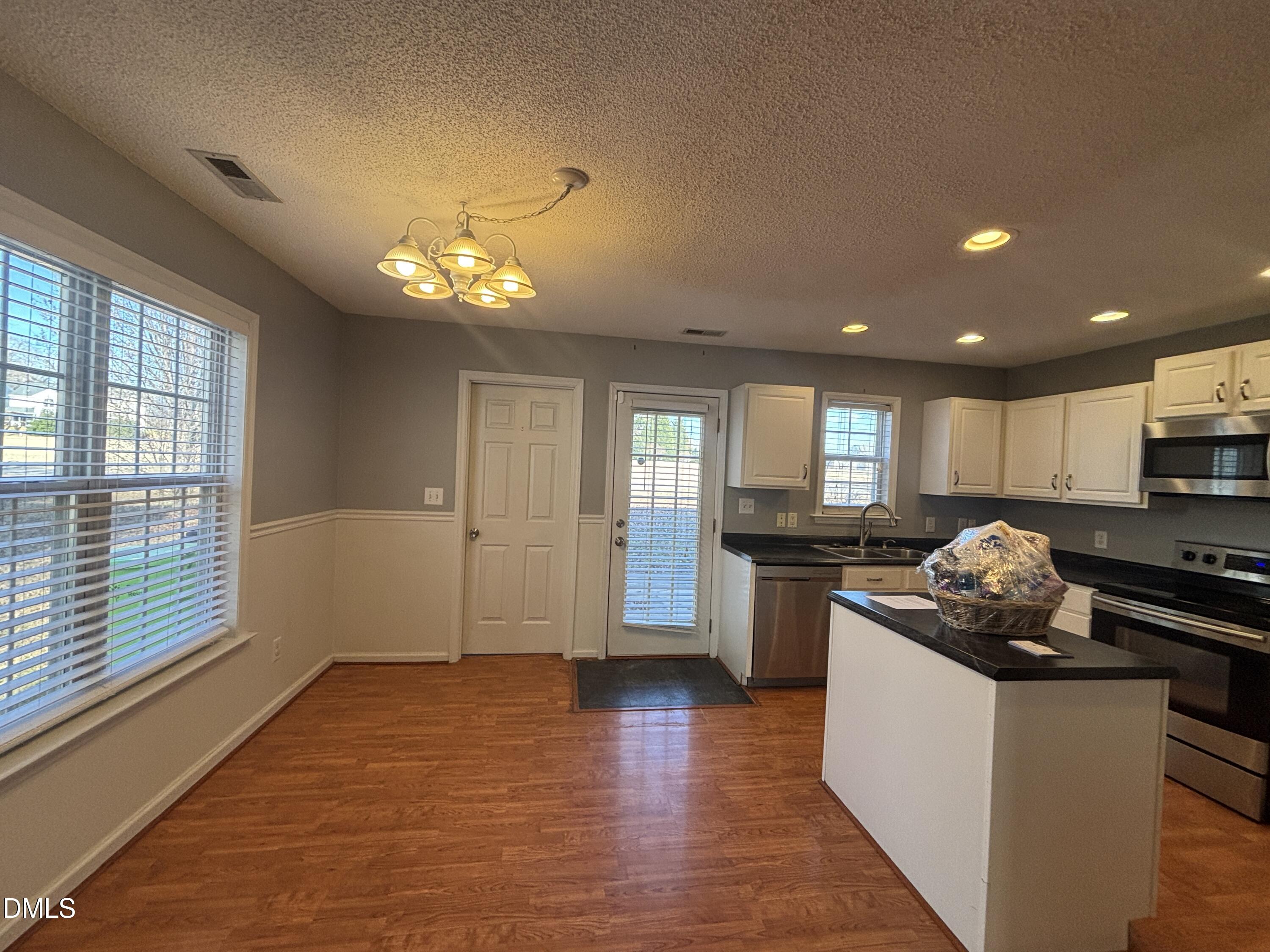 1704 Crag Burn Lane Raleigh, NC 27604 - Photo 12 of 22 a kitchen with kitchen island granite countertop stainless steel appliances stove a sink and a refrigerator