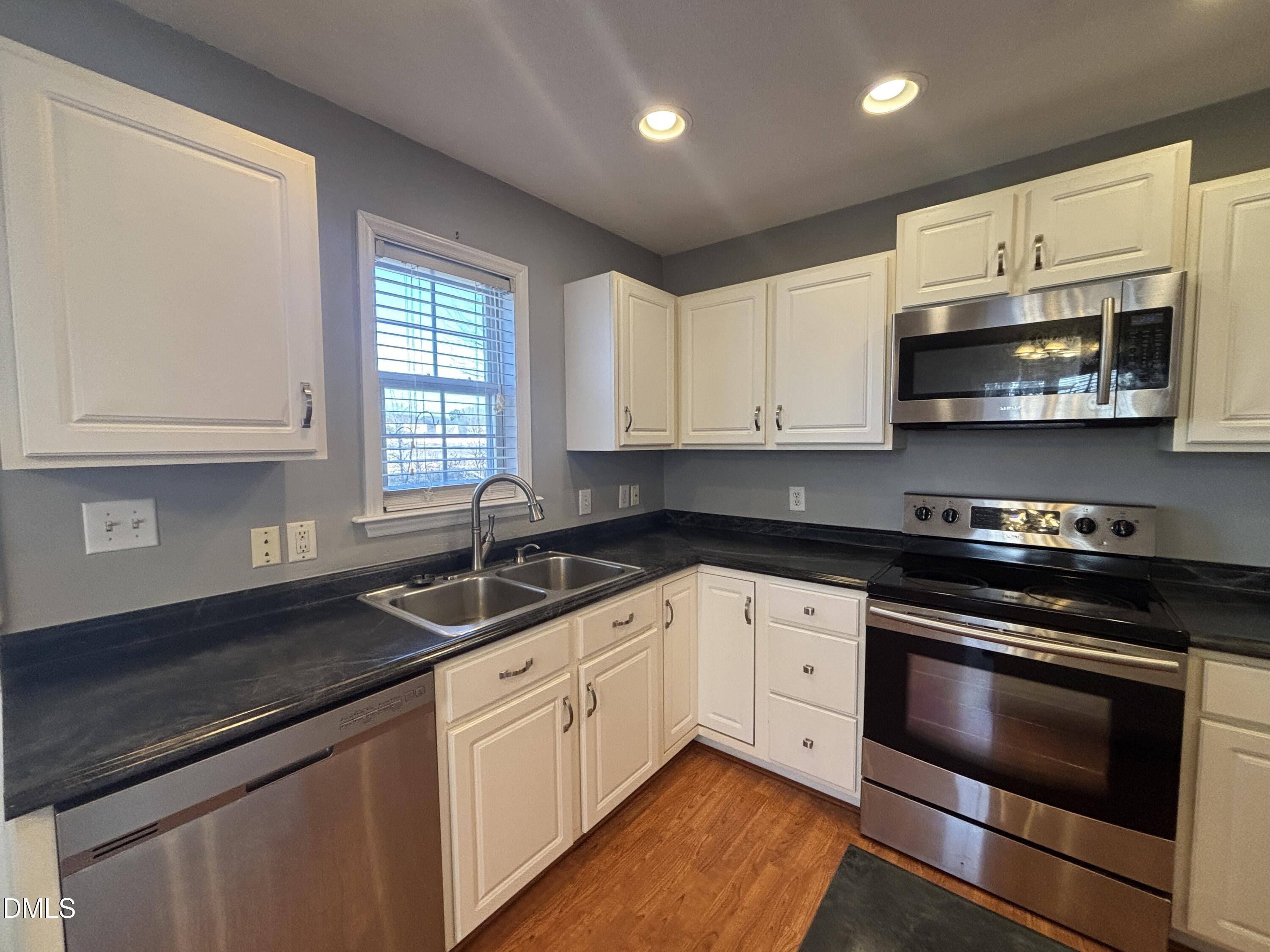 1704 Crag Burn Lane Raleigh, NC 27604 - Photo 13 of 22 a kitchen with stainless steel appliances granite countertop a sink stove and microwave