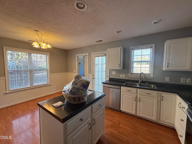 a kitchen with granite countertop a sink cabinets and window